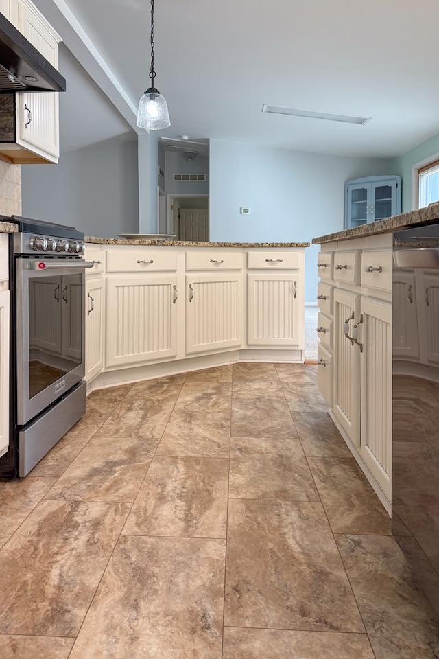 kitchen featuring tasteful backsplash, hanging light fixtures, wall chimney range hood, light stone countertops, and stainless steel electric range