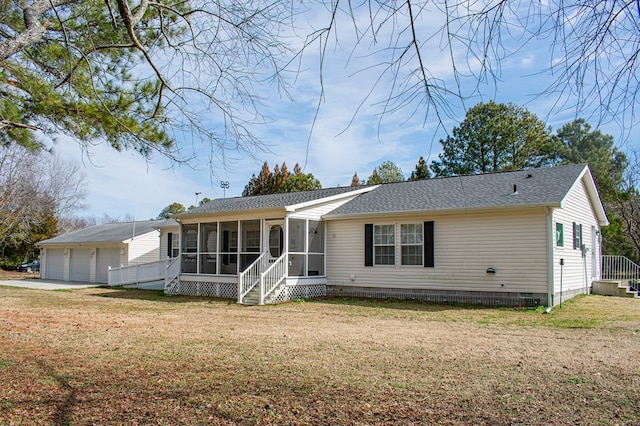 view of front of house featuring an outbuilding, crawl space, a front yard, and a sunroom