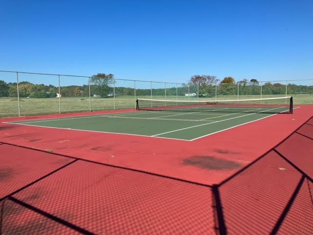 view of tennis court featuring community basketball court and fence