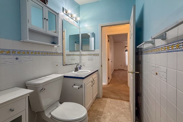 bathroom with tile walls, vanity, and toilet