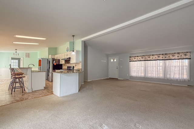 kitchen with tasteful backsplash, white cabinets, lofted ceiling with beams, a breakfast bar, and decorative light fixtures