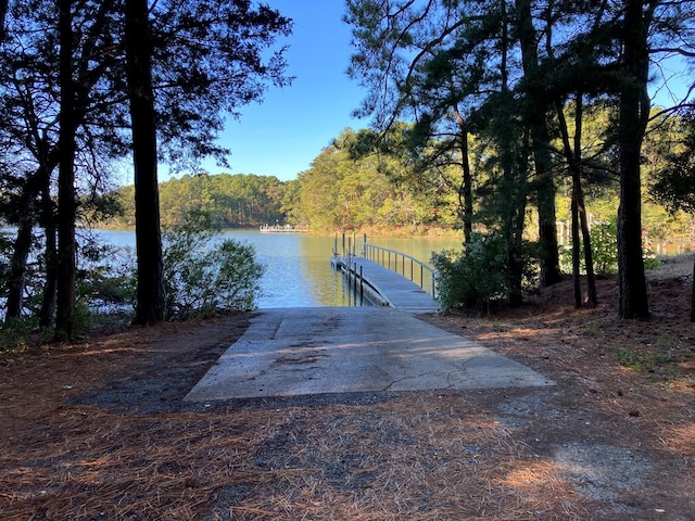 view of dock with a water view and a wooded view