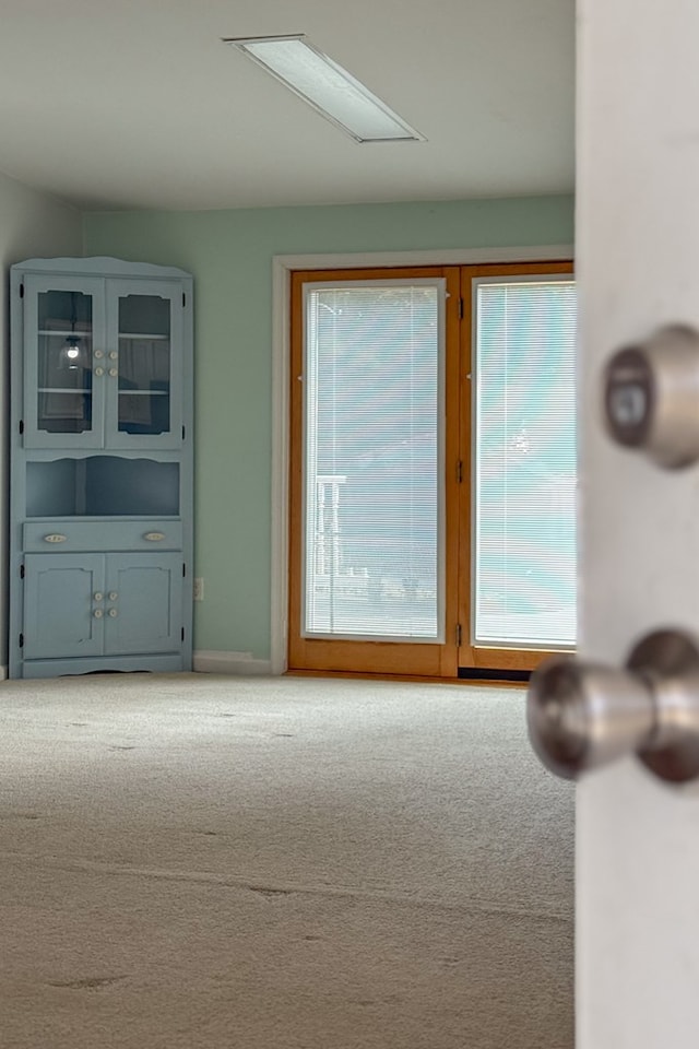 entryway featuring baseboards and carpet flooring