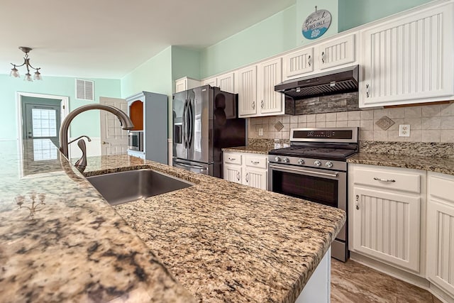 kitchen with stainless steel appliances, white cabinets, a sink, and under cabinet range hood