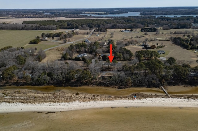 birds eye view of property featuring a view of the beach, a water view, and a rural view