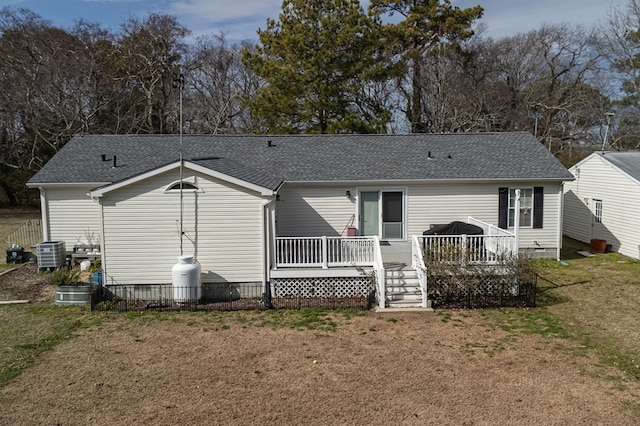 back of house with a deck, a yard, roof with shingles, and central air condition unit