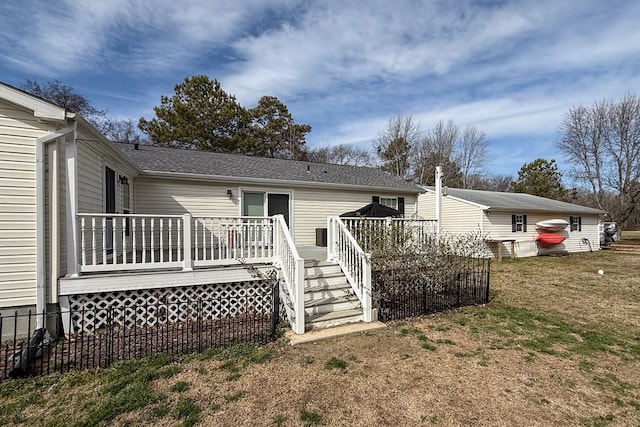 rear view of house with a deck and a lawn