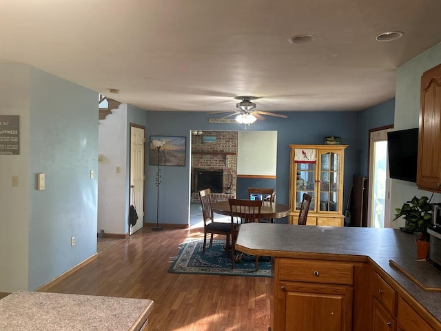 9370 Southwind Rd, Atlantic, VA 23303 - kitchen with a ceiling fan, dark wood-style floors, a peninsula, baseboards, and brown cabinets