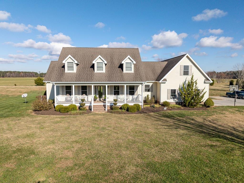 cape cod-style house featuring a front lawn and a porch