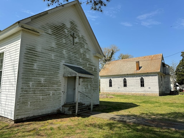 rear view of house featuring a yard and entry steps