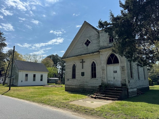 view of front of home with entry steps and a front lawn