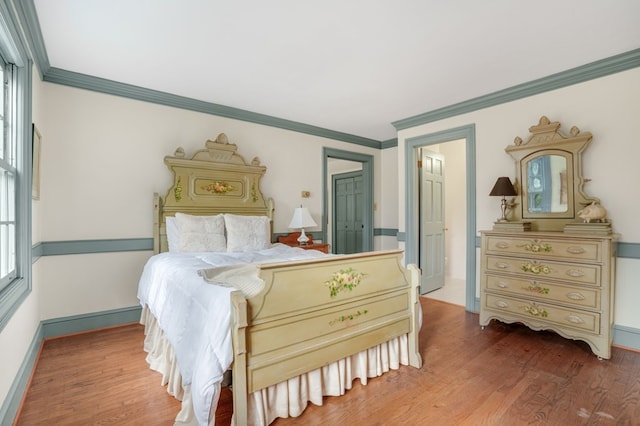 bedroom featuring a closet, hardwood / wood-style floors, and ornamental molding