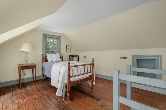 bedroom featuring dark wood-type flooring and vaulted ceiling