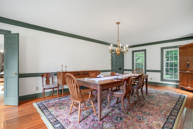 dining room featuring light hardwood / wood-style flooring, a chandelier, and ornamental molding