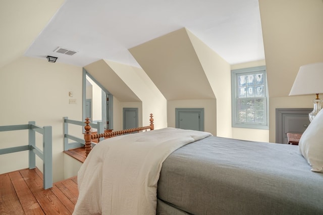 bedroom featuring hardwood / wood-style floors and lofted ceiling