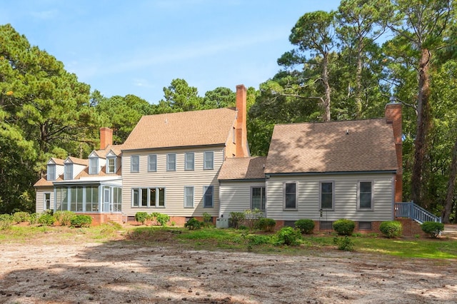 rear view of house featuring a sunroom and central AC unit