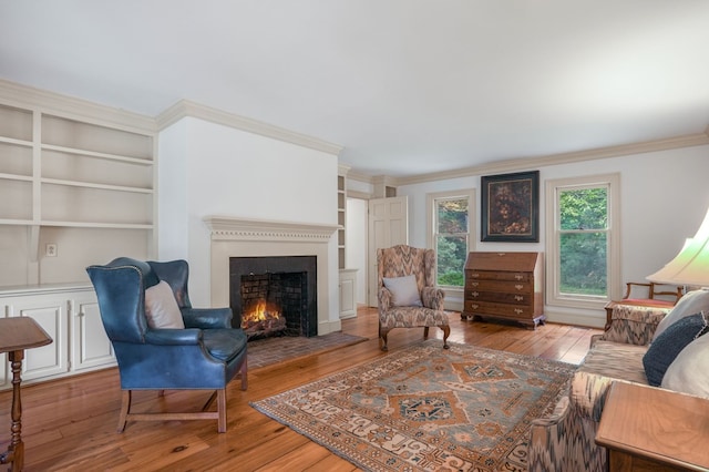 living room featuring built in shelves, crown molding, and light hardwood / wood-style floors