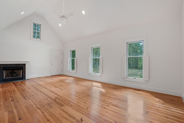 unfurnished living room with ceiling fan, high vaulted ceiling, and light hardwood / wood-style flooring