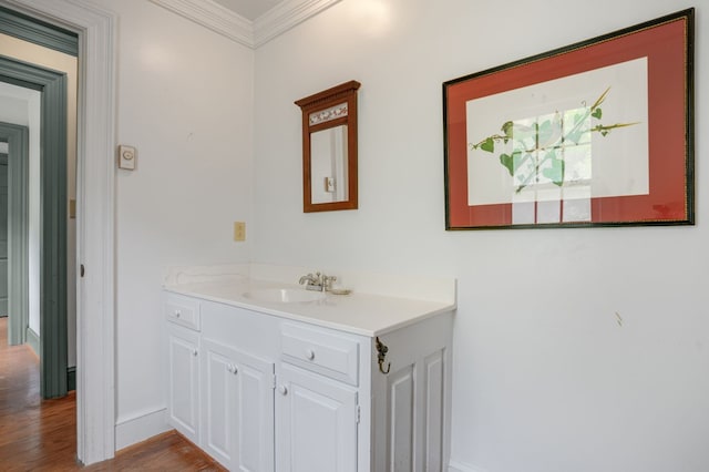 bathroom with vanity, wood-type flooring, and ornamental molding