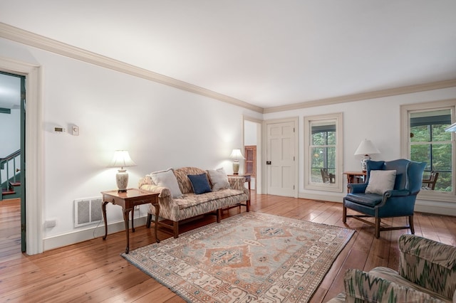 living room with light hardwood / wood-style flooring and crown molding