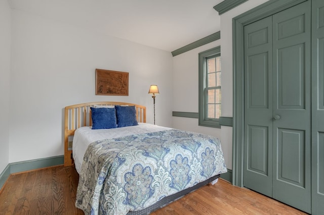 bedroom featuring hardwood / wood-style floors, a closet, and ornamental molding