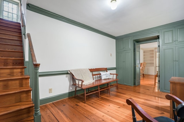 living area featuring light hardwood / wood-style flooring and ornamental molding