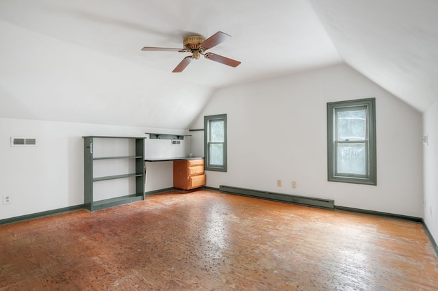 additional living space with vaulted ceiling, a wealth of natural light, a baseboard heating unit, and ceiling fan