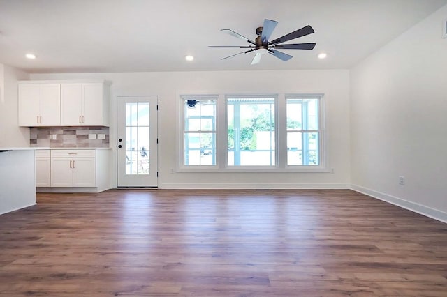 unfurnished living room with dark wood-type flooring, ceiling fan, and plenty of natural light