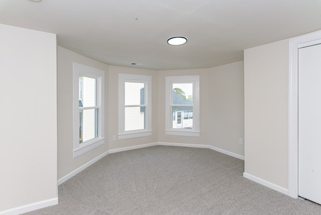 carpeted spare room featuring a healthy amount of sunlight