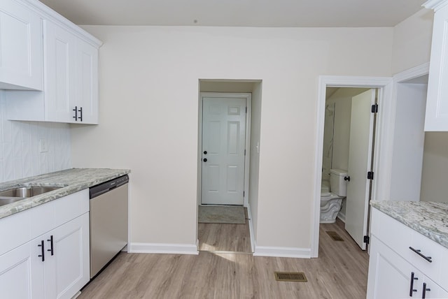 kitchen featuring light stone counters, stainless steel dishwasher, light wood-type flooring, and white cabinets