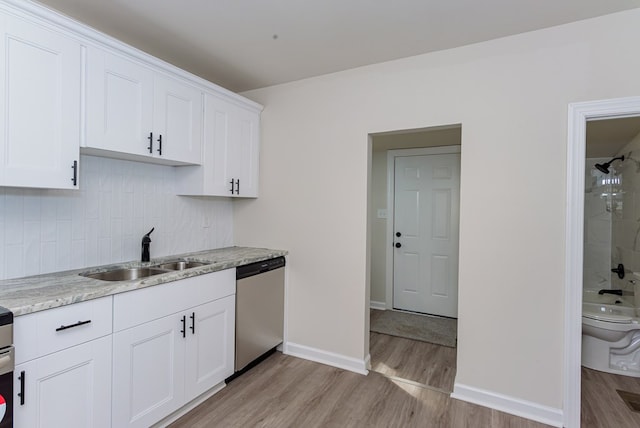 kitchen featuring sink, white cabinets, stainless steel dishwasher, light hardwood / wood-style floors, and light stone counters