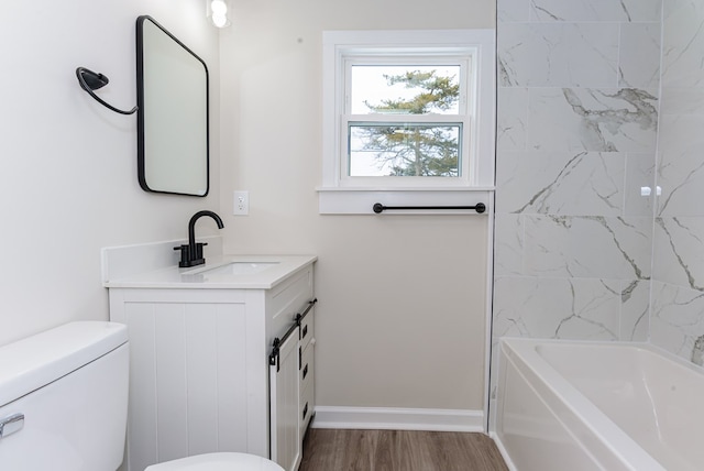 full bathroom featuring tiled shower / bath combo, vanity, wood-type flooring, and toilet