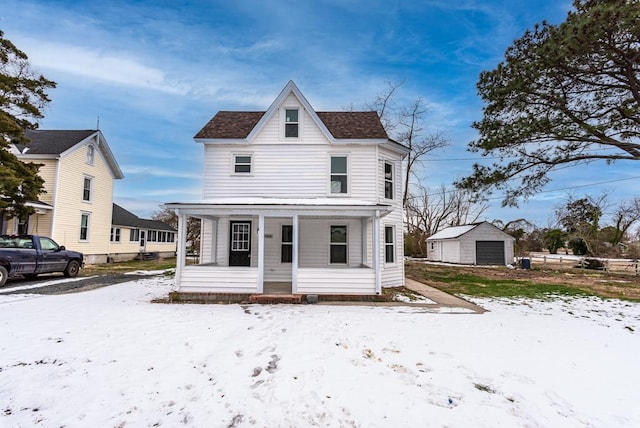 view of front of house featuring a garage, a porch, and an outbuilding