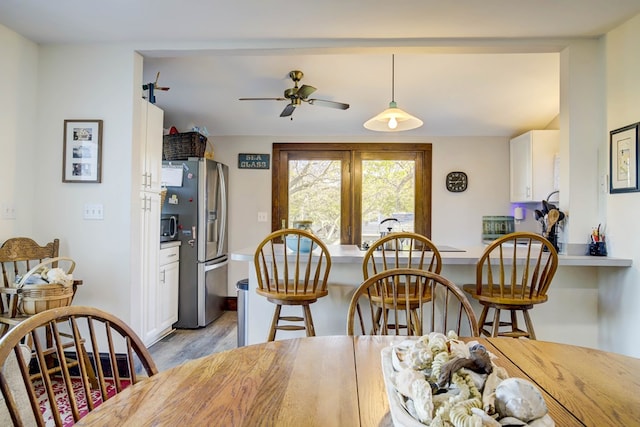 dining area with light hardwood / wood-style flooring and ceiling fan