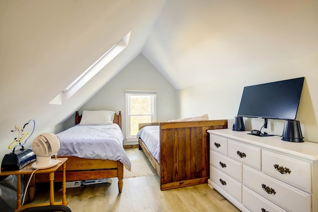 bedroom featuring light hardwood / wood-style floors and vaulted ceiling with skylight