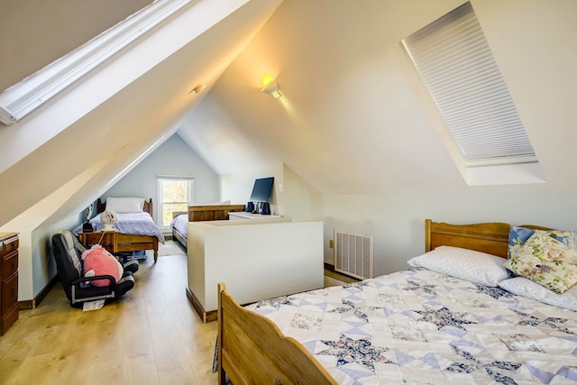 bedroom with light hardwood / wood-style floors and lofted ceiling