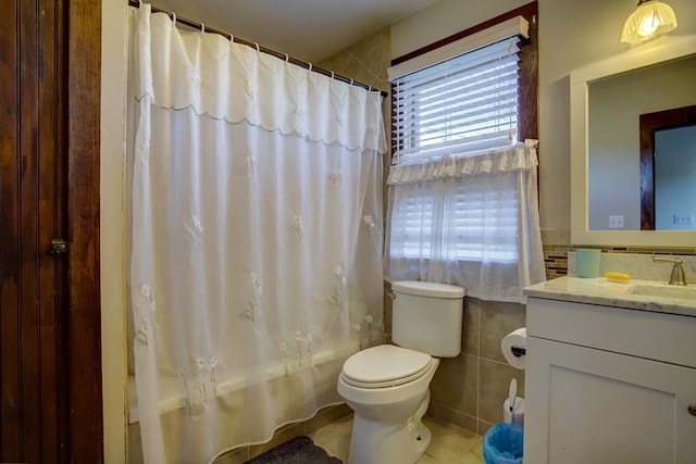 full bathroom with vanity, shower / bathtub combination with curtain, tile walls, tile patterned flooring, and toilet