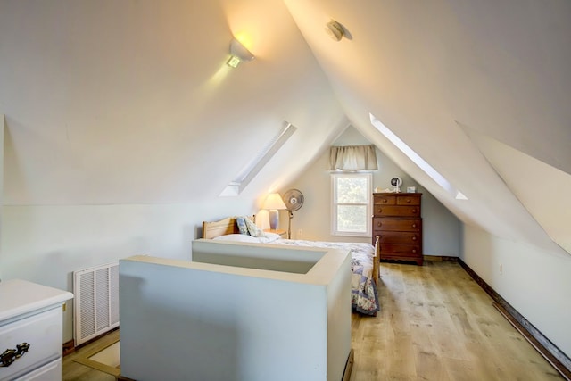 bedroom featuring light hardwood / wood-style floors and lofted ceiling with skylight