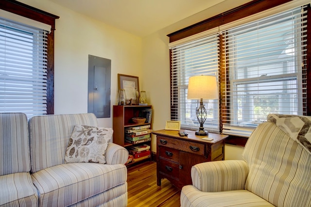 living area with hardwood / wood-style floors, a healthy amount of sunlight, and electric panel