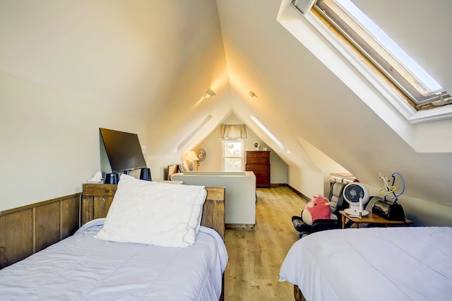 bedroom with light wood-type flooring and lofted ceiling with skylight