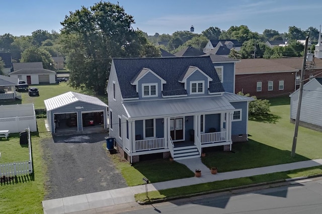 614 Strawberry St, Cape Charles, VA 23310 - view of front of property featuring a garage, covered porch, an outbuilding, a front yard, and a metal roof