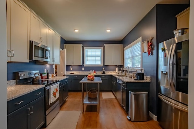 614 Strawberry St, Cape Charles, VA 23310 - kitchen featuring appliances with stainless steel finishes, light wood finished floors, light stone countertops, and recessed lighting