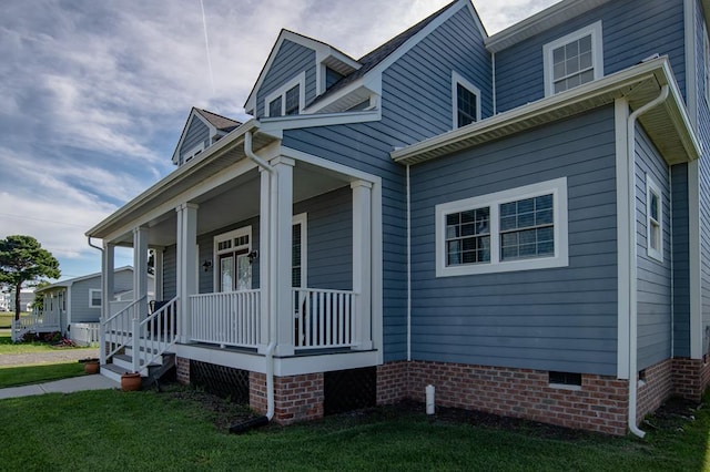 614 Strawberry St, Cape Charles, VA 23310 - view of side of home featuring covered porch, crawl space, and a lawn