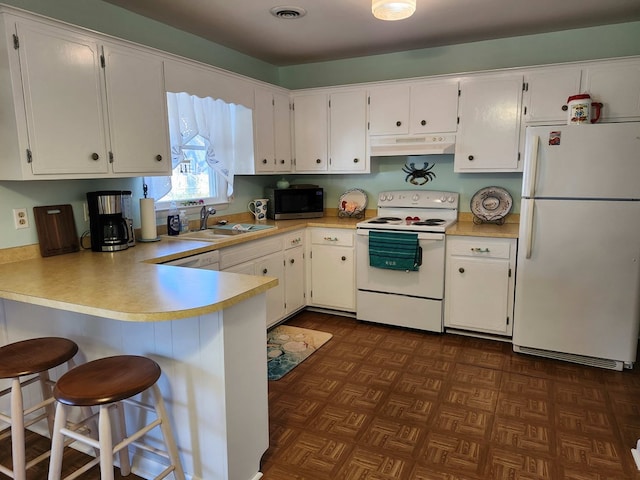 kitchen with kitchen peninsula, white appliances, white cabinetry, and sink