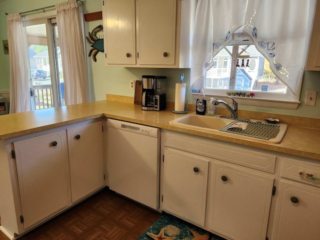 kitchen featuring a wealth of natural light, sink, white dishwasher, and dark parquet floors