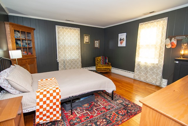 11510 Poplar Ave, Exmore, VA 23350 - bedroom with a baseboard heating unit, wood finished floors, and ornamental molding
