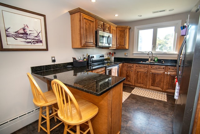 11510 Poplar Ave, Exmore, VA 23350 - kitchen with stainless steel appliances, a peninsula, brown cabinets, dark stone countertops, and recessed lighting