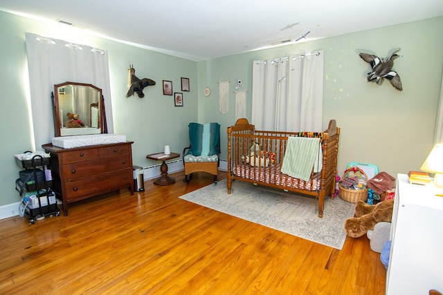 11510 Poplar Ave, Exmore, VA 23350 - bedroom with light wood-type flooring and a baseboard radiator