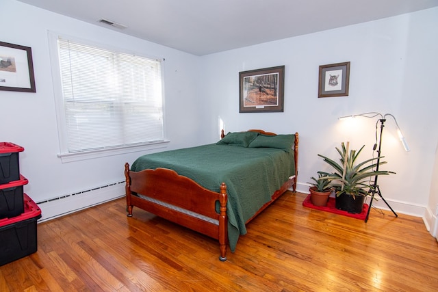 11510 Poplar Ave, Exmore, VA 23350 - bedroom with a baseboard heating unit and wood finished floors