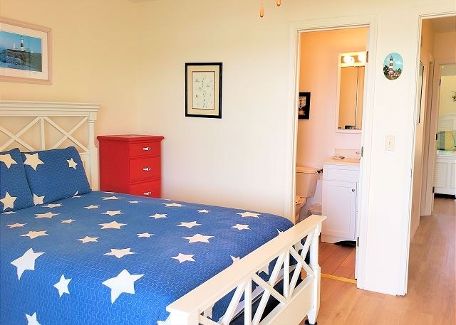 bedroom featuring hardwood / wood-style flooring and ensuite bathroom